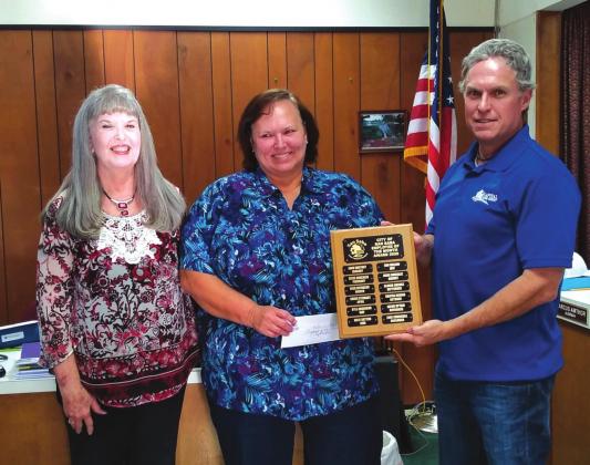Alderman Marcus Amthor assists Kim Wilson, Financial Assistant, in displaying an Employee of the Month plaque with her name engraved for selection as the City's Employee of the Month for September. Kim also received a gift certificate to a local restaurant. At her right is Charlene Lindsay, Finance Director, who also took part in the formal presentation. (Staff Photo)