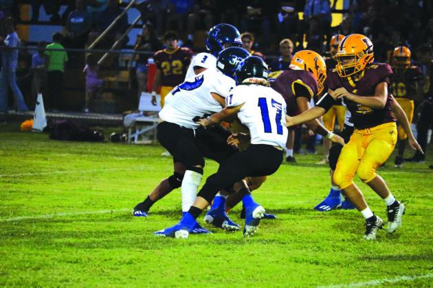Coyotes #17 Billy Perry, #32 Cohen Tharp, and #3 Braxton Ethridge fighting hard as they play on the Hornets’ home turf in last Friday night’s game, September 9th.  Photo by Pam Starr