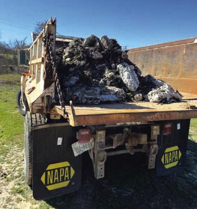Once the backhoe was full of the grease logs, they would dump them in the dump truck.
