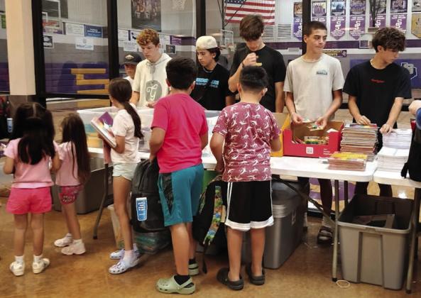 The children or their parents would go by the tables, take whatever school supplies they needed, and put them in their new backpack. | Photo by Djuana Payton