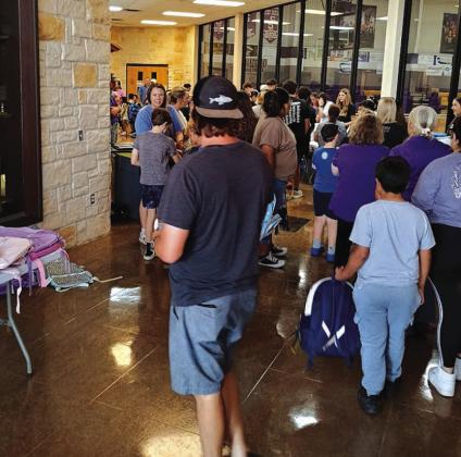 These parents and students have just picked up their backpack and are on their way to the school supplies table. | Photo by Djuana Payton