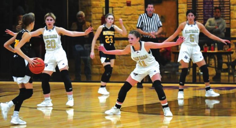 The San Saba High School girls varsity basketball team plays defense on Tuesday, December 14, during the Lady Dillos’ 48-27 victory at home vs. rival Goldthwaite High School. From left to right: senior guard Jaedah Lambert (20), sophomore guard Jenna Lambert (11), and senior forward Nojemi Martinez (5) are locked in. (Photo by Rita Boultinghouse)