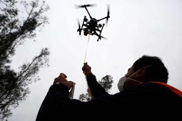 A drone pilot delivers aid to people in the Catapilco, Valparaiso Region of Chile during the COVID-19 lockdown. Texas A&amp;M researchers examined whether drones could also be used to deliver COVID-19 test kits. Marcelo Hernandez/Getty Images