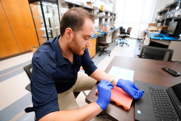 Texas A&amp;M doctoral student Kaan Sel, who co-authored the study, demonstrates how the e-tattoo is applied to the wrist. Laura McKenzie/Texas A&amp;M Division of Marketing &amp; Communications