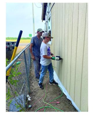 Jeff Fauley and Gage Falkner putting up siding