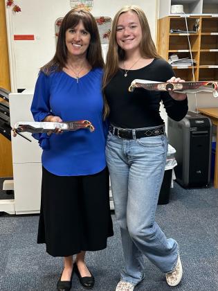 Payton Duggan, Chair to the San Saba County Chamber of Commerce Junior Directors, presents eclipse glasses to Jennifer Bordner, Superintendent of Cherokee ISD.