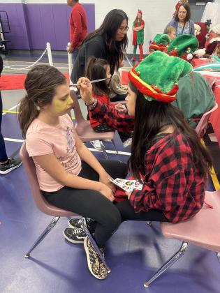 SSES student, Emmaline Ketchum, getting her face painted by SSHS Art student, Zayla Morales.