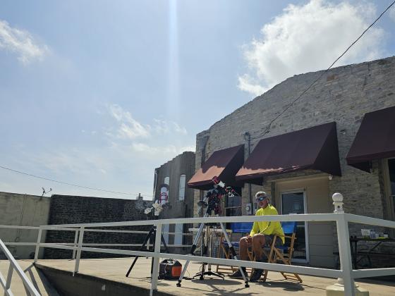 Billy Prewitt set up his solar eclipse capturing equipment on the porch of Burnhams Lodging for the Total Solar Eclipse event on April 8th, 2024. You can see the sun shining down from the  clear skies. Photo by Michael Brand, San Saba
