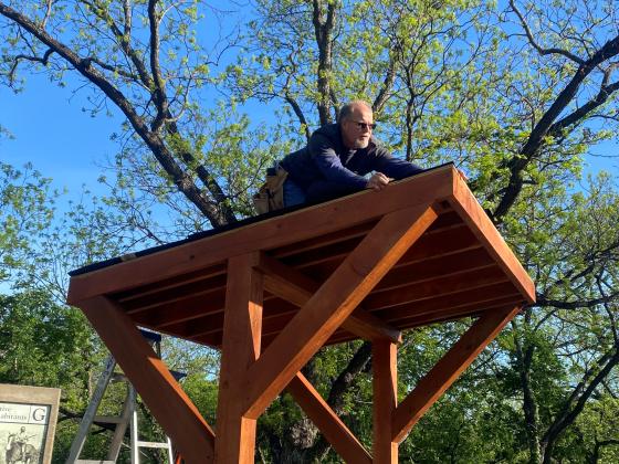 An LCRA volunteer roofing the covered bench during the Steps Forward Day Project