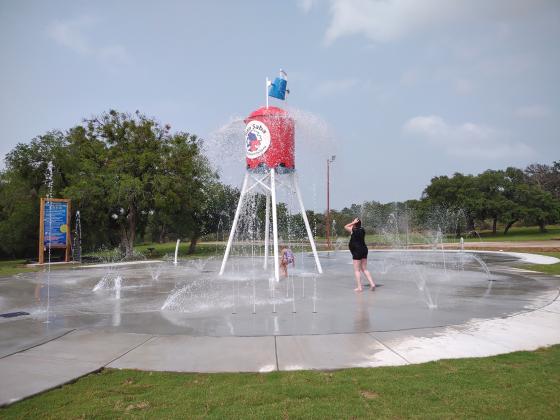 Katelyn and Zavanna McCoury catching the water dumping out of the bucket on top of the Water Tower.