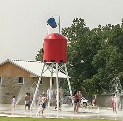 The kids have plenty of water to splash around while waiting on the water to dump from the tower. Photo by Carolyn Boswell Preece