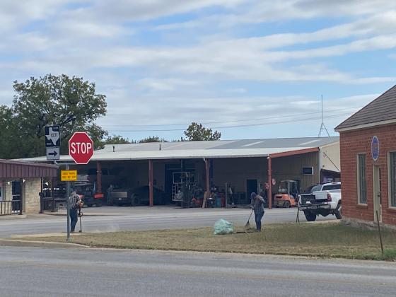 Two men working on their own to cleanup a city downtown business lot.