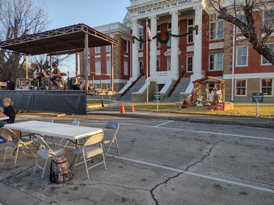 Clara and Cody Elkin on stage in front of the Courthouse singing "Mary Did You Know" while just to the right of the state is a manger scene of Mary looking down at baby Jesus. (Djuana Payton)