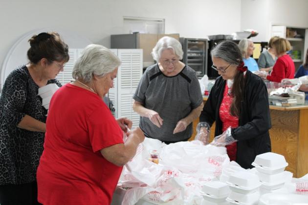 Volunteers packaging to-go meals