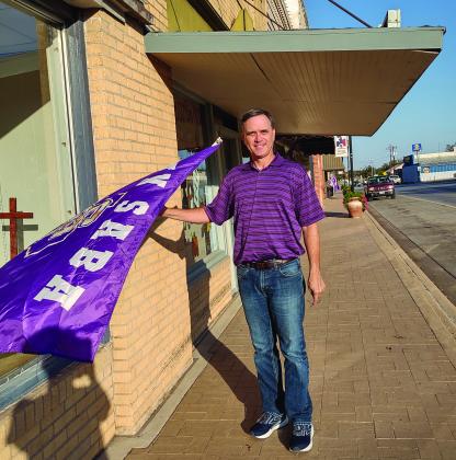 Rotary Club's Kevin Shahan putting up flags for the Dillos' game - photo by Djuana Payton