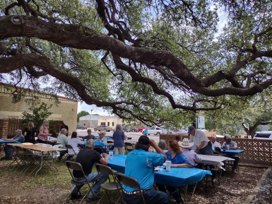 Tables were set up under the trees in this beautiful outdoor setting for the Ribbon Cutting Ceremony.  | Photo by Djuana Payton
