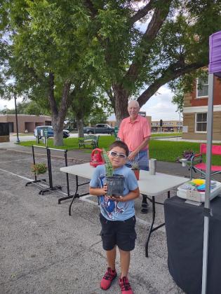 Gio has a huge smile on his face as he walks away with his new plant purchased from Mr. Van Gorp at Saturday's Pecan Capital Trade Days. Photo by Djuana Payton