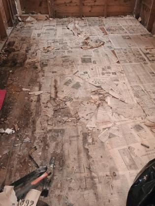 Newspaper covered floor that was uncovered
