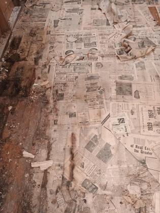 Newspaper covered floor that was uncovered