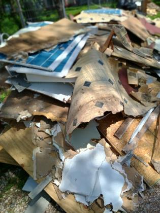 Piles of the flooring and newspapers found under the flooring during flood cleanup