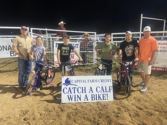 Calf scramble winners- Saturday night | Vance Bauer and Marcus Amthor representing Capital Farm Credit presenting bicycles to: Rexton Hunt, Bobby Verette, Angel Cervantes, and Harper Brown
