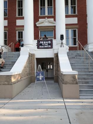 Cynthia Brand is setting up the banner that reads "Jesus is the Answer" for the event.  Photo by Djuana Payton