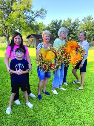Board volunteer members ares shown here after fluffing wreaths to give a few downtown lamp posts a feel of fall. Board Members:  Lucia Martinez (and her son, Matteo), Gale Ivy, Rhonda Killion, Sandra Vaughn (hidden), and Cissy Williams. Not pictured:  photographer, Debbie Shahan. Other members not available are Marcie Butler and Kathleen Hawkins. Courtesy of Sarah Saldivar