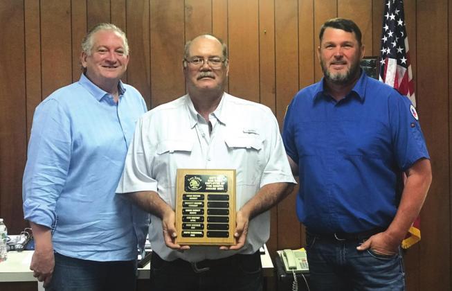 Wayne Yarbrough, Parks Department Lead Man, displays an Employee of the Month plaque with his name engraved for selection as the City's Employee of the Month for June. He also received a gift certificate to a local restaurant. At Wayne's right is Alderman Shawn Oliver and to his left is Eugene Bessent, Parks Department Supervisor, both taking part in the formal presentation.
