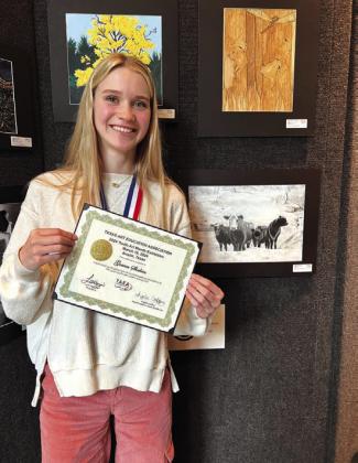 Gracen Shahan next to her artwork displayed at the Bob Bullock Museum Photo by Shara Wright