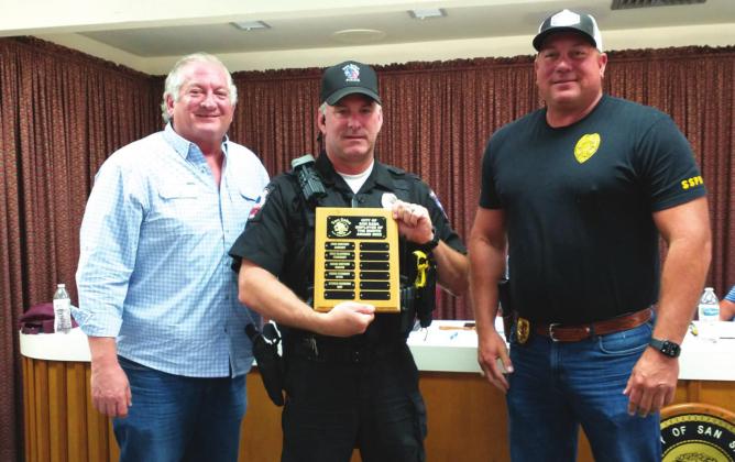 Steven Newkirk, Police Officer with the San Saba Police Department, displays an Employee of the Month plaque with his name engraved for selection as the City's Employee of the Month for May. He also received a gift certificate to a local restaurant. At Steven's right is Alderman Shawn Oliver, and on his left is Police Chief John Bauer taking part in the presentation. (Staff Photo)
