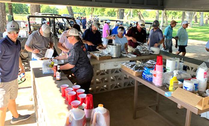 Members and golfers enjoy a pleasant outdoor meal in the shade under tournament pavilion!