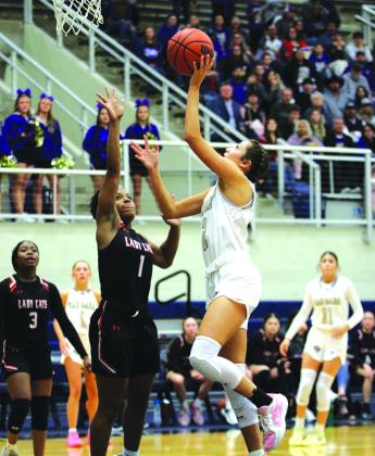 Sr Cinzlea Stanton driving the lane scoring two of her 29 points on the night, which set her up for a career total of 2,000 points and was recognized at the end of Friday nights game.