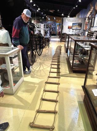 C.K. Stevenson is at the museum with the rope ladder made by his father in 1935.