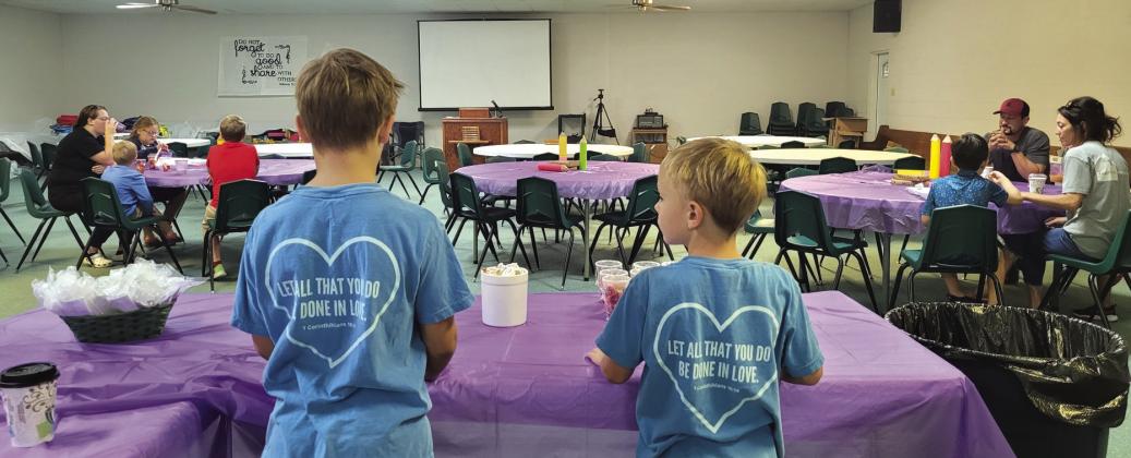 William (left) and Jesse (right) Hibler are manning their post helping out as servers at the Back to School Breakfast. They are wearing the church’s ‘event shirts’ that quote the Scripture 1 Corinthians 16:14 on the back: “Let all that you do be done in love.” Courtesy of Stephanie Hibler