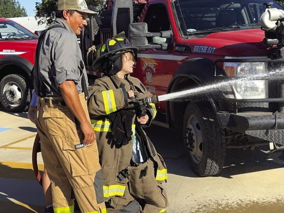 SS VFD member teaching Darion Young the power of water in the fire hose.