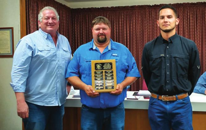 November Employee of the Month Lucas Watson, Water Department employee, displays an Employee of the Month plaque with his name engraved for selection as the City's Employee of the Month for November. He also received a gift certificate to a local restaurant. At Lucas' right is Alderman Shawn Oliver, and on his left is Robert Hensley, Water Wastewater Leadman, taking part in the formal presentation. (Staff Photo)