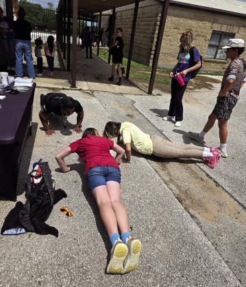 Annabella Morris met her pushup challenge with the support of her friend Alyssa Wilson and SSgt Van Buren completing the pushup count alongside her. Courtesy of Mona Parrish