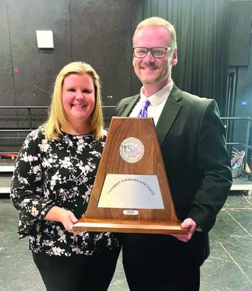 Band Directors Chans and Misty Moellendorf holding the prestigious Sweepstakes trophy. | Courtesy of Chans Moellendorf