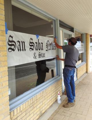 Devin Cordoza is seen here installing the Perforated Vinyl sign on our front window this week. Photo by Carolyn Boswell-Preece