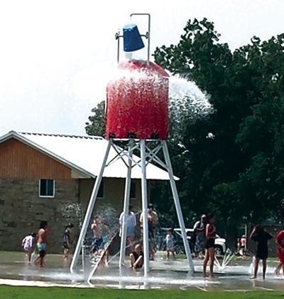 The water buckets dumps when it is full; the water then runs over the top of the tower onto the playing kids below. Photo by Carolyn Boswell Preece