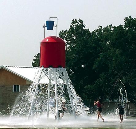 Water is dumped out from the bottom of the tower on the expectant kids below. One parent said they timed it, and it happens about every two  minutes. Photo by Carolyn Boswell Preece