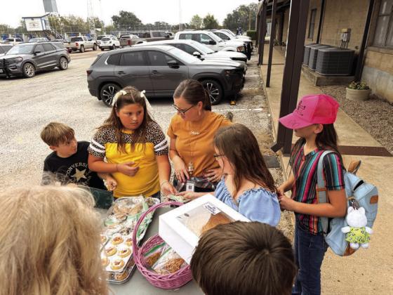 Jaxon Owen and Phoebe Valdez helping customers at the bake sale. Courtesy of Shannon Padgett