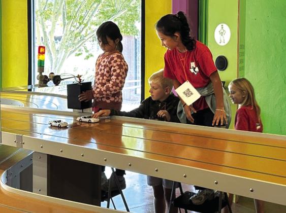 Juliana Rangel, Dallas Bryan, Alex Rocha, and Cara Sue Broyles race their electric cars at the Science Mill.