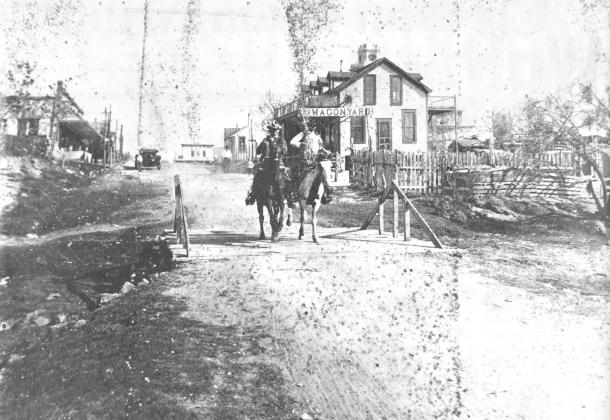 WAGON YARD DAYS–Jack Edwards loans this picture of the Smithwick Hotel and Wagon Yard in about 1915. The horsemen riding south on Cherokee Street are Charley Pruitt (L) and O. K. Harkey. The J. M. Carter building on the left is now Bagley's and at the far end of the street is R. A. Brite's Variety Store where C &amp; M House of Gifts is now located. Printed in the April 9, 1981 issue of the San Saba News &amp; Star.