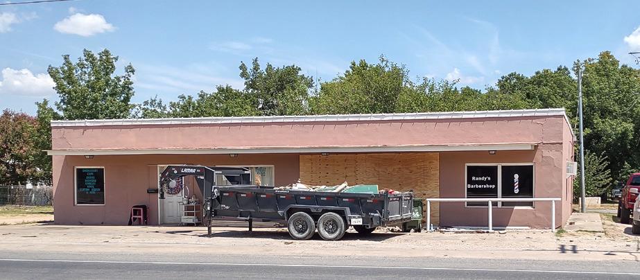 By Sunday afternoon after church, the front of Randy's Barber shop had been boarded up. The full trailer in front shows the hard work that was done to get the storefront cleaned up.