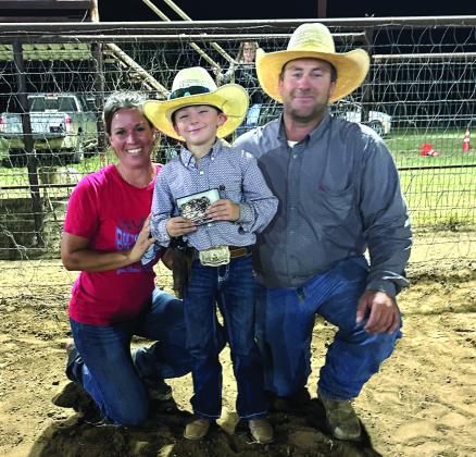 Pee Wee All-Around Cowboy is Bo Taylor. Awarding his buckle are directors Misty and Nick Taylor.