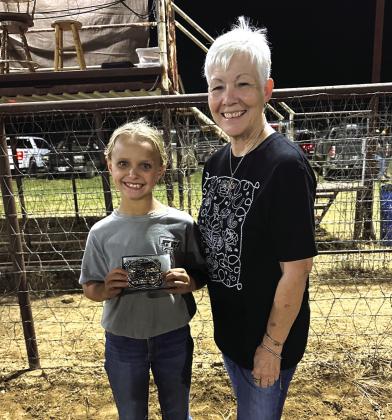 JuniorAll-Around Cowgirl is Sailor Baker. Awarding her buckle is director Paula Miller.