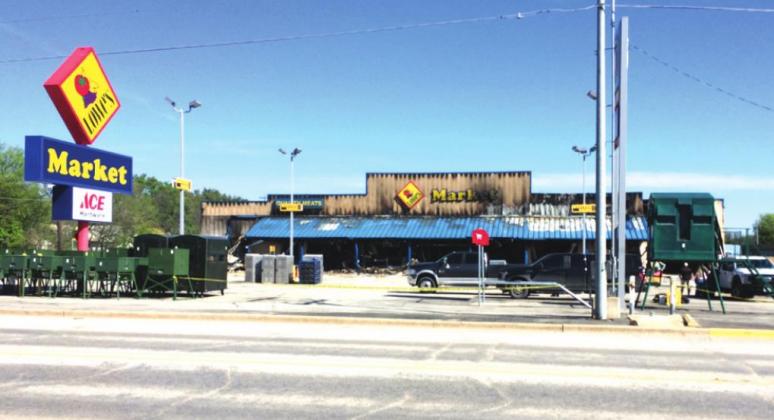 Lowe’s Market shown Tuesday, March 24th, about mid-morning. Charred remains are seen still standing with the Lowe’s sign standing proudly untouched. Temporary relocation plans and remodeling are underway and may come to fruition as early as this coming Saturday. Photo by Alice Smith