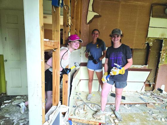 These strong young people are working hard tearing out this wall.  Photo courtesy of Corina Fauley