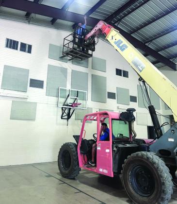 City employees Eugene Bessent (driving) and Darrell Lackey (in the basket) hard at work replacing the insulation at the Civic Center. Photo courtesy of Scott Glaze